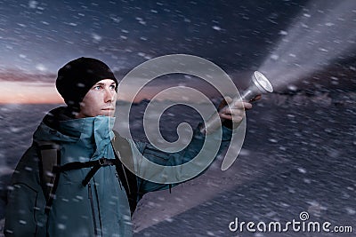 Mountain tourist with a lantern in hand lighting the way in the dark of night. Stock Photo