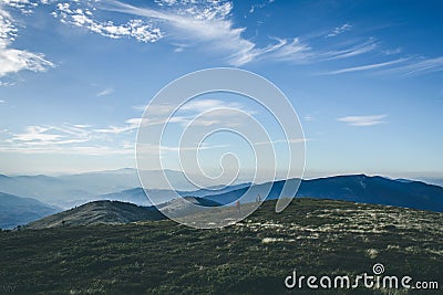 Mountain tracking. People in distance on blue sky background. Seasonal photo in cold tones Stock Photo