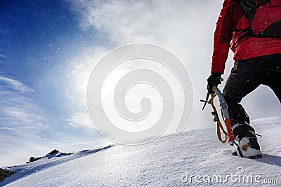 Mountaineer climbing a snowy peak in winter season. Stock Photo