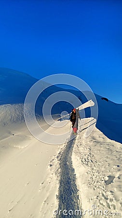 Mountaineer reaches the top of a snowy mountain Editorial Stock Photo