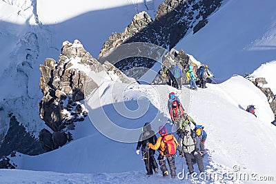 Mountaineer reaches the top of a snowy mountain in a sunny winter day Editorial Stock Photo