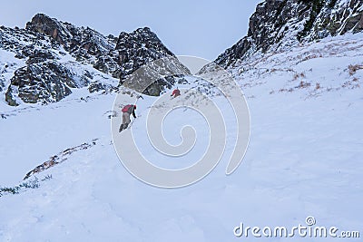 Mountaineer reaches the top of a snowy mountain in a sunny winter day. tatras mountain Stock Photo