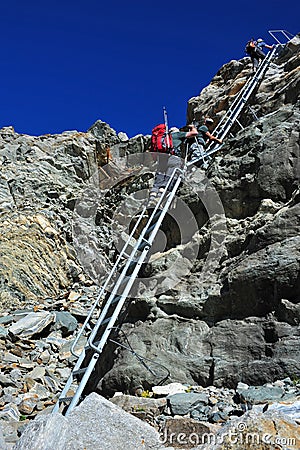 Mountaineers climbing down a steep ladder Editorial Stock Photo