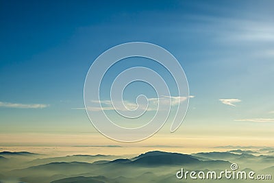 Mountains clouds blue sky and fog photographed from on mountaintop. Stock Photo