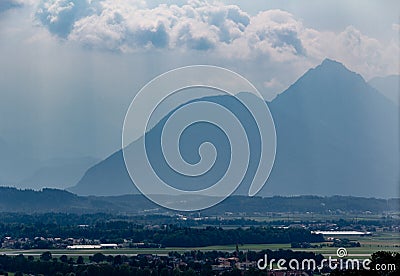 The mountains are just silhouettes in the distance due to fog blocking the view seen from Hohensalzburg Stock Photo