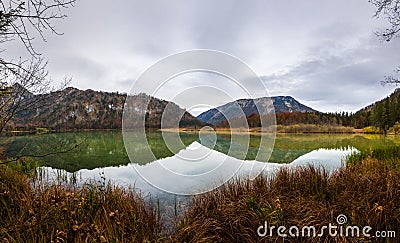 mountains and lake with beautiful reflection with grass on the shore panorama Stock Photo