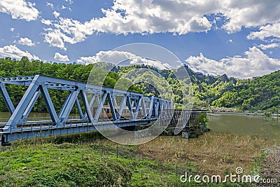 Mountains landscape with passenger train crossing a bridge Stock Photo