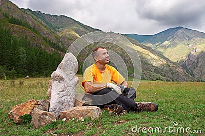 Mountains, men and idol. Stock Photo