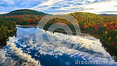 Mountains in peak fall surround reflective lake in early morning light Stock Photo