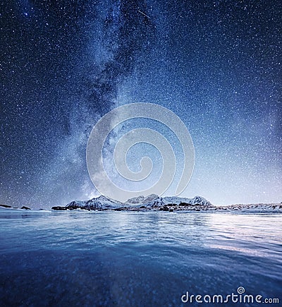 Mountans and reflection on the water surface at the night time. Sea bay and mountains at the night time. Milky way above mountains Stock Photo