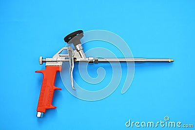 Mounting foam sprayer gun pistol tool on blue background Stock Photo