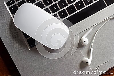 Mouse and earphone on laptop computer keyboard Stock Photo