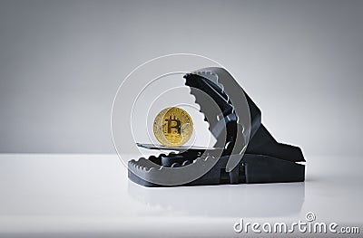 Mousetrap with gold bitcoin on wood table . Concept risks and dangers of investing to bitcoin Stock Photo