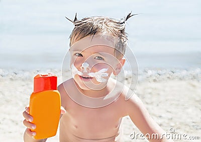 Moustaches cat drawing sunscreen (suntan lotion) on hipster boy face before tanning during summer holiday. Stock Photo