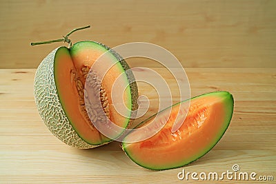 Mouthwatering orange color juicy ripe fresh muskmelon sliced from whole fruit Stock Photo