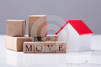 Move Text In Front Of Cardboard Boxes And House Model Stock Photo