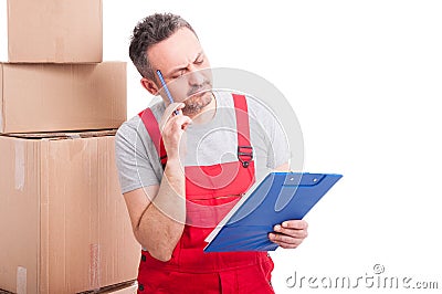 Mover guy making thinking gesture and holding clipboard Stock Photo