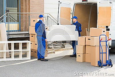 Movers Carrying Sofa Outside Truck On Street Stock Photo