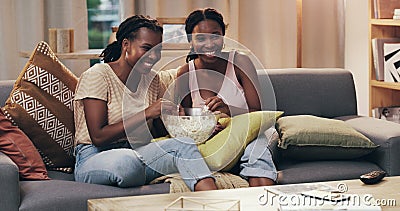 Movie night, happy and women with popcorn on the sofa for a television show, film or comedy. Smile, relax and African Stock Photo