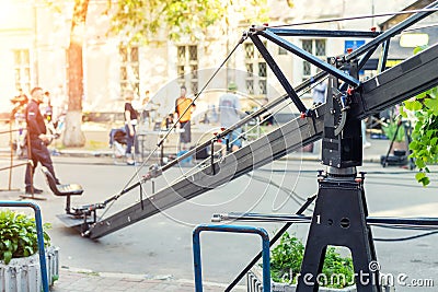 Movie set with professional equipment and media production team on city street. Outdoor film making. Big camera crane with Stock Photo