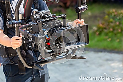 Movie shooting or video production and film crew team with camera equipment. Video camera operator working with equipment. Directo Stock Photo