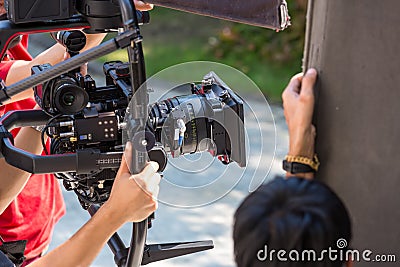 Movie shooting or video production and film crew team with camera equipment. Video camera operator working with equipment. Directo Stock Photo