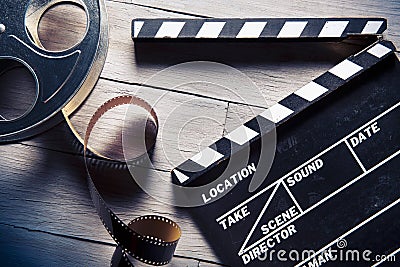 Movie slate and film reel on wood Stock Photo