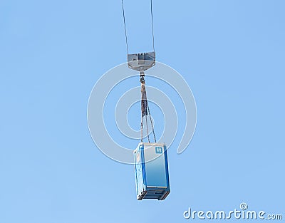 Moving a blue porta-potty through the air Stock Photo