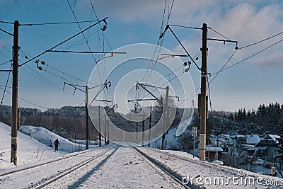 A moving figure near the railroad. Winter railway landscape. Stock Photo