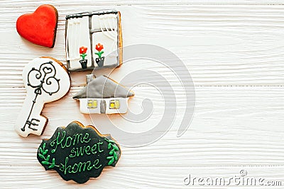 Moving in new house, Welcome home set. Key, house, plant,heart, welcome sign cookies on white wood, flat lay with space for text. Stock Photo