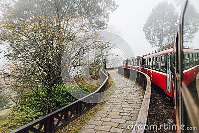 Moving red trains in Alishan Forest Railway stop with motion blur trees outside in Alishan, Taiwan Editorial Stock Photo