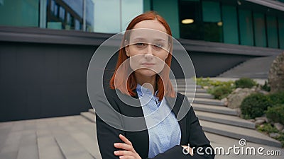 Moving shot business portrait in city Caucasian serious confidence businesswoman posing with hands crossed outdoors Stock Photo