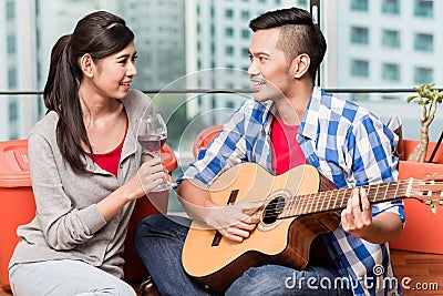 After moving together young man plays love song for his girlfrie Stock Photo