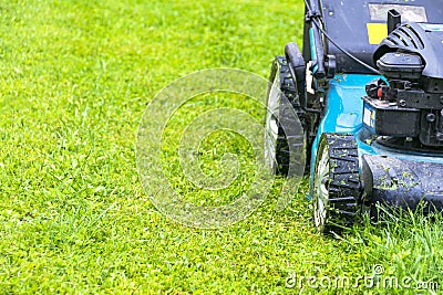 Mowing lawns, Lawn mower on green grass, mower grass equipment, mowing gardener care work tool, close up view, sunny day. Stock Photo