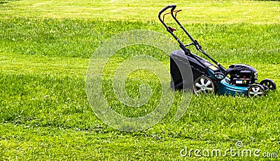 Mowing lawns. Lawn mower on green grass. mower grass equipment. mowing gardener care work tool. close up view. sunny day. Stock Photo