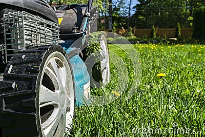 Mowing lawns, Lawn mower on green grass, mower grass equipment, mowing gardener care work tool, close up view, sunny day. Soft lig Stock Photo