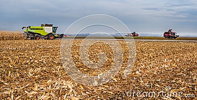 Mown corn field where harvesters are working, beet harvest on the horizon Editorial Stock Photo