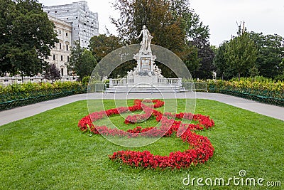 Mozart Statue with flower decoration in the form of a musical treble clef key, Vienna, Austria Stock Photo