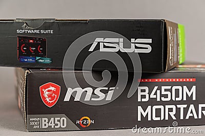 MSI B450 MORTAL MAX motherboard and ASUS GFORCE GTX 1650 graphics card against gray background. Boxs with the new computer Editorial Stock Photo