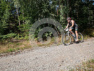 Mtb rider in black jersey hold brakes in front of right turn into forest Editorial Stock Photo