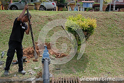 Muadzam Shah, Malaysia- September 1st, 2021 :Plumber installing new HDPE pipe in the main drains Editorial Stock Photo