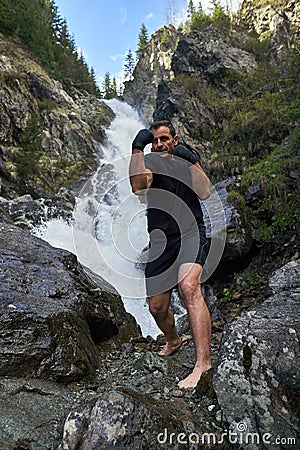 Muay thai fighter training by the waterfall Stock Photo