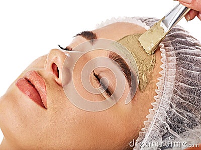 Mud facial mask of woman in spa salon. Face massage. Stock Photo