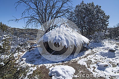 Mud hut survival shelter covered in snow Stock Photo