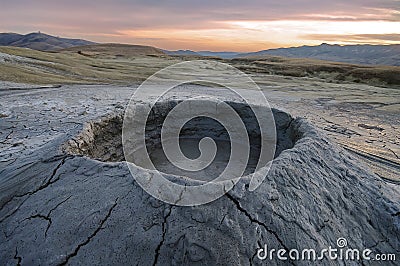 Bubbling mud. Mud volcano at sunset - landmark attraction in Buzau, Romania Stock Photo