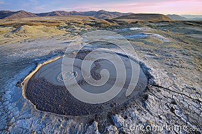 Bubbling mud. Mud volcano at sunset - landmark attraction in Buzau, Romania Stock Photo