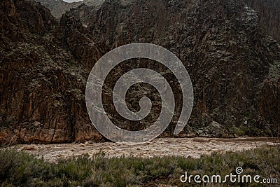 Muddy Waters of the Colorado Flow Through Granite Rapids Stock Photo