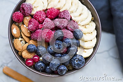 Muesli bowl with berries, banana and almonds, oatmeal breakfast bowl top view with berries Stock Photo