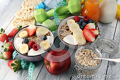 Muesli with dairy and fruit, healthy lifestyle. bowl of cereal, fruit and dumbbell. Stock Photo