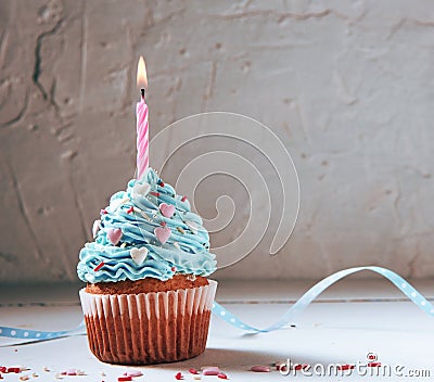 Muffin or a small cake with a burning candle. concept of congratulation, holiday. Stock Photo